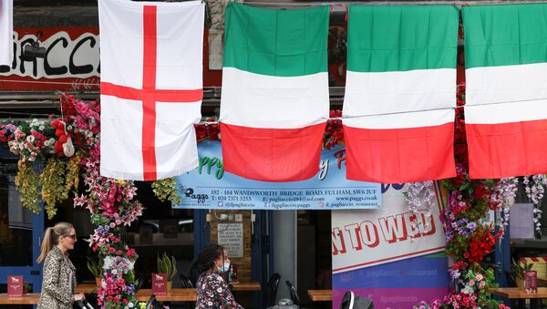 People walk past a restaurant displaying Italy and England flags, in London, Britain, 9 July 2021.  - Sputnik International