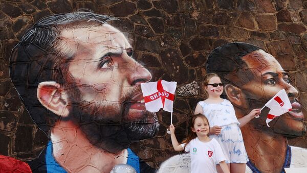 Soccer Football - England fans pose for a photograph in front of a giant mural created by street artist Nathan Parker of Gareth Southgate, Harry Kane and Raheem Sterling ahead of the Euro 2020 final against Italy - Bullring, Nuneaton, Britain - July 10, 2021 - Sputnik International