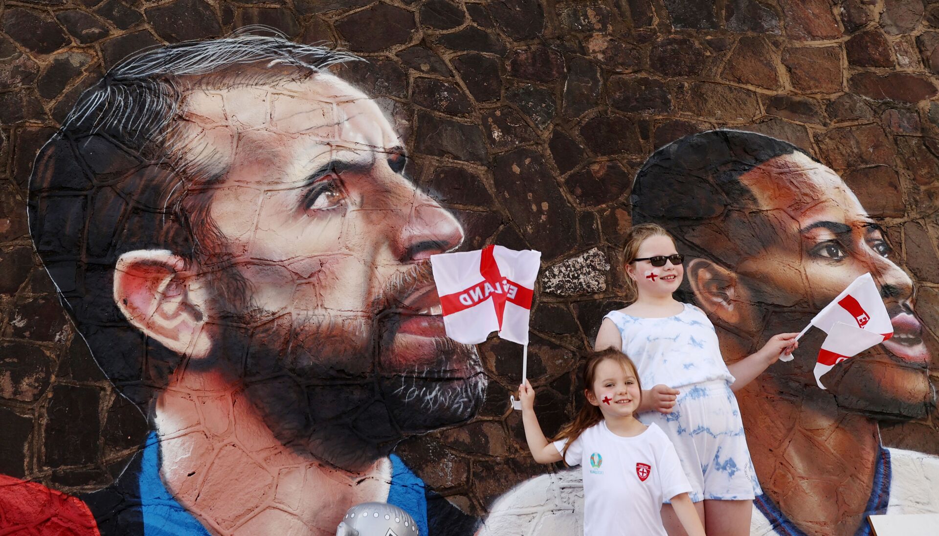 Soccer Football - England fans pose for a photograph in front of a giant mural created by street artist Nathan Parker of Gareth Southgate, Harry Kane and Raheem Sterling ahead of the Euro 2020 final against Italy - Bullring, Nuneaton, Britain - July 10, 2021 - Sputnik International, 1920, 07.09.2021