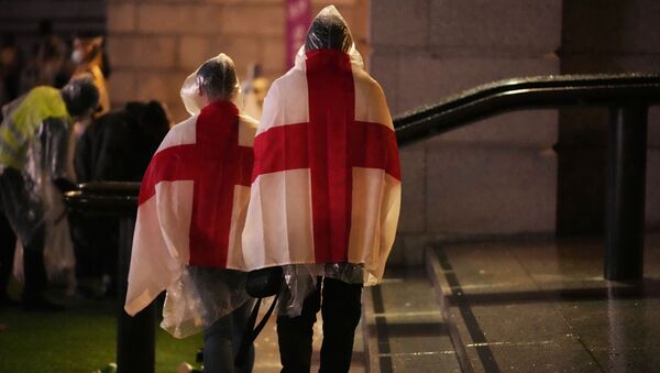 England supporters wear flags as they leave the designated fan zone at Trafalgar Square in London, Sunday, July 11, 2021, after Italy won the Euro 2020 soccer championship final match between England and Italy played at Wembley Stadium. - Sputnik International