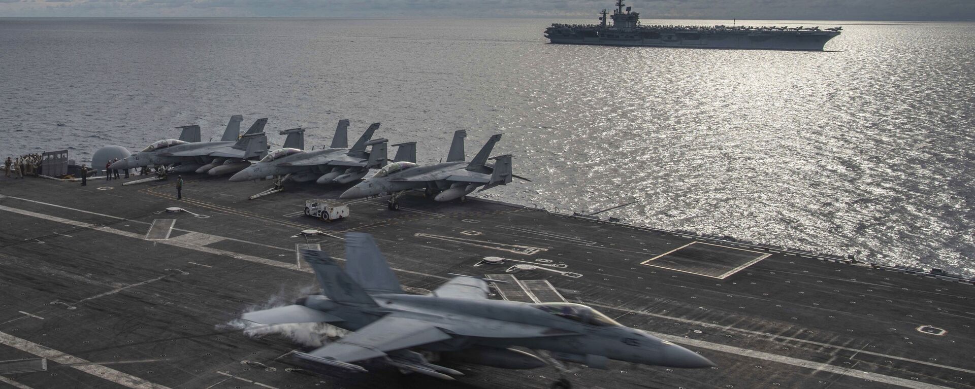 In this photo provided by U.S. Navy, an F/A-18E Super Hornet lands on the flight deck of the USS Ronald Reagan (CVN 76), as USS Nimitz (CVN 68) steams alongside in the South China Sea, Monday, July 6, 2020. - Sputnik International, 1920, 09.10.2021
