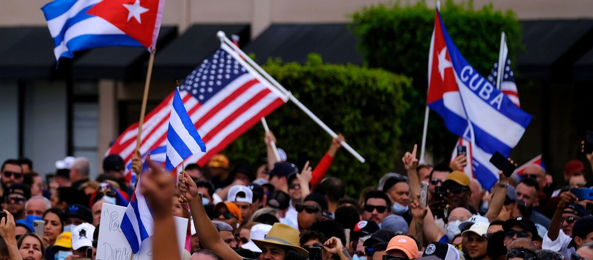 Emigres in Little Havana wave American and Cuban flags as they react to reports of protests in Cuba against the deteriorating economy, in Miami, Florida, U.S., July 11, 2021 - Sputnik International, 1920, 12.07.2021
