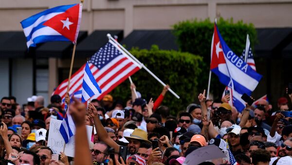 Emigres in Little Havana wave American and Cuban flags as they react to reports of protests in Cuba against the deteriorating economy, in Miami, Florida, U.S., July 11, 2021 - Sputnik International