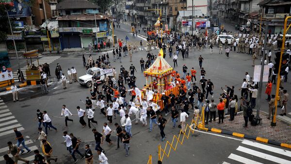 Hindu devotees pull a Rath or a chariot of Lord Jagannath, along a road escorted by police during the annual Rath Yatra, or chariot procession, during the ongoing coronavirus disease (COVID-19) outbreak, in Ahmedabad, India, July 12, 2021 - Sputnik International