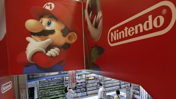 FILE - In this May 7, 2014, file photo, shoppers walk under the logo of Nintendo and Super Mario character, left, at an electronics store in Tokyo. Japanese Prime Minister Shinzo Abe's appearance as Super Mario in the Rio Olympics closing ceremonies on Sunday, Aug. 21, 2016, was a crowd-pleasing reminder of how much the game helped spur on the videogame revolution in the U.S. and globally. - Sputnik International
