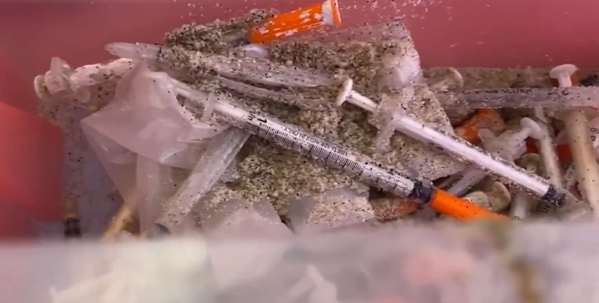 Screenshot captures an image of a bevy of syringes that were recently collected along the shores of several New Jersey beaches. Officials have speculated that the occurrence is the result of overflooded sewer systems that forced untreated water to be channeled back into regional waters. - Sputnik International, 1920, 07.09.2021