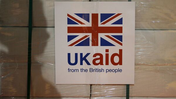 A UK aid label is attatched to a box containing kitchen sets, stored at a UK Aid Disaster Response Centre where humanitarian supplies are being collected to be airlifted to Iraq at Cotswold Airport near the village of Kemble, Gloucestershire, southern England on August 14, 2014 - Sputnik International