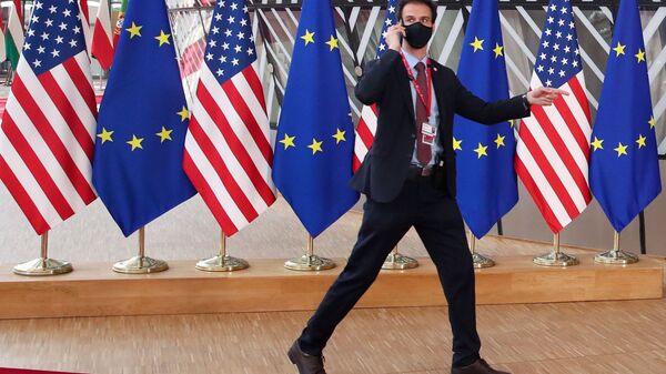 A security guard walks near EU and U.S. flags, before the EU-US summit, in Brussels, Belgium June 15, 2021 - Sputnik International