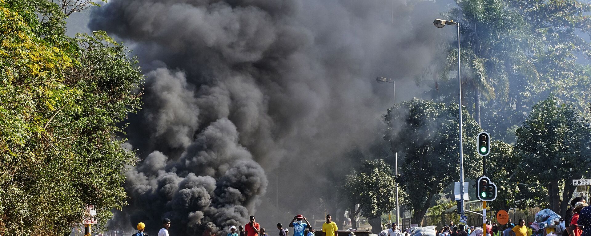 Looters outside a shopping centre alongside a burning barricade in Durban, South Africa, Monday July 12, 2021 - Sputnik International, 1920, 16.07.2021