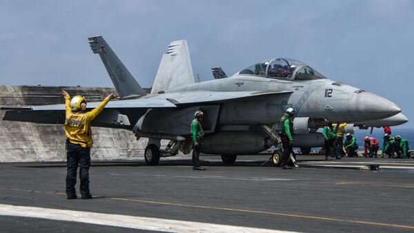 Sailors prepare an F/A-18F Super Hornet fighter jet, attached to the “Diamondbacks” of Strike Fighter Squadron (VFA) 102, to launch from the flight deck of aircraft carrier USS Ronald Reagan (CVN 76) during flight operations in the Arabian Sea, 8 July. - Sputnik International