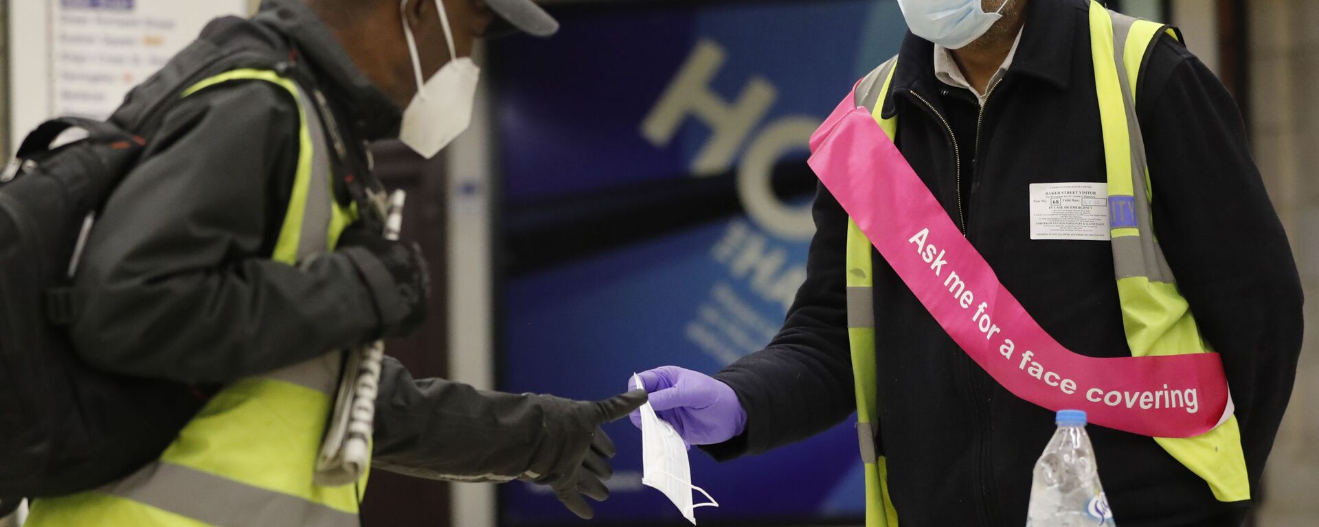 A London Underground worker, right, hands over a free face masks to a passenger at London's Baker Street station, Tuesday, June 9, 2020. Wearing a face mask will become compulsory on the London TFL public transport service starting from June 15, 2020, as a safety measure to contrast the COVID-19 pandemic.  - Sputnik International, 1920