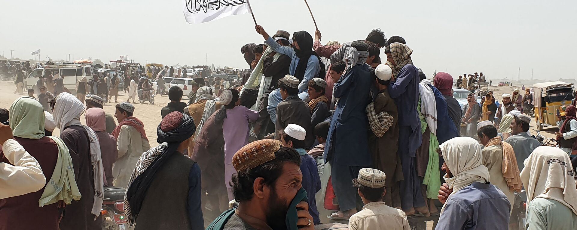 People wave Taliban flags as they drive through the Pakistani border town of Chaman on July 14, 2021, after the Taliban claimed they had captured the Afghan side of the border crossing of Spin Boldak along the frontier with Pakistan - Sputnik International, 1920, 23.07.2021