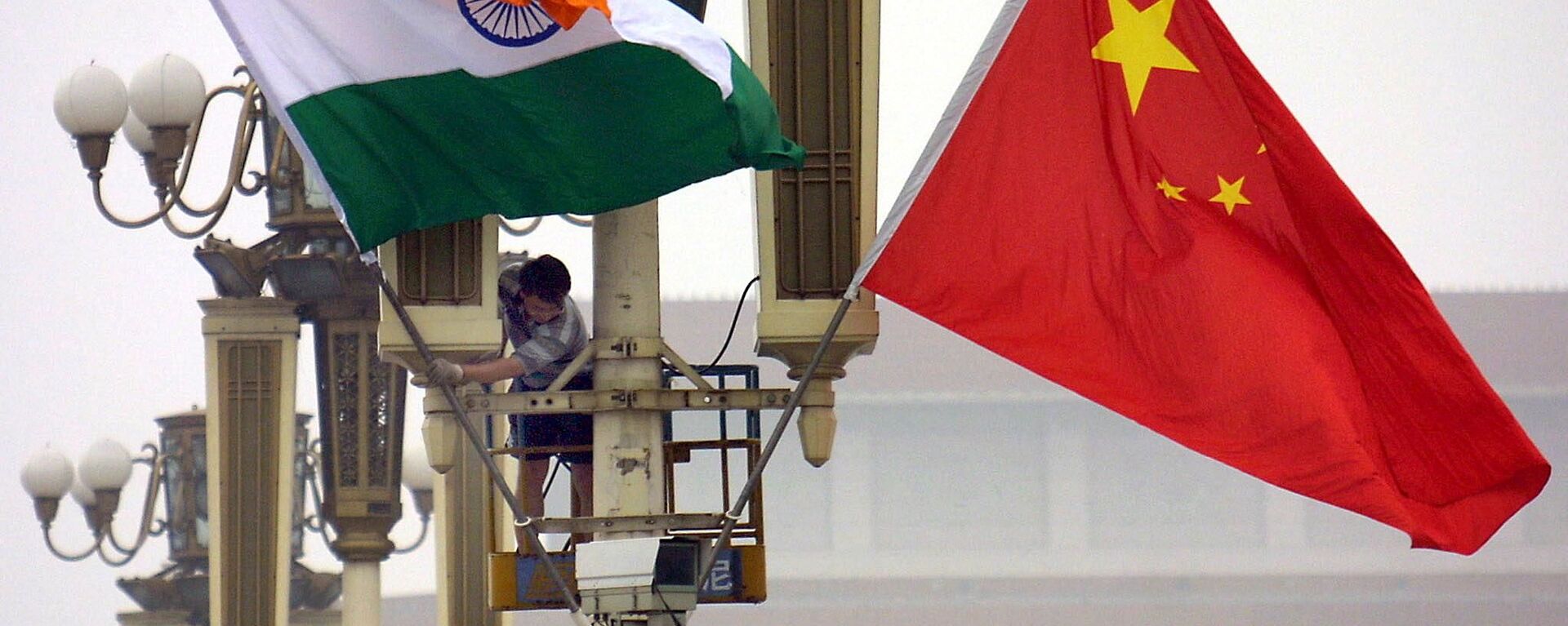 Workers put up the Indian flag (L) alongside the Chinese flag on Tiananmen Square in Beijing, 22 June 2003 - Sputnik International, 1920, 30.08.2022
