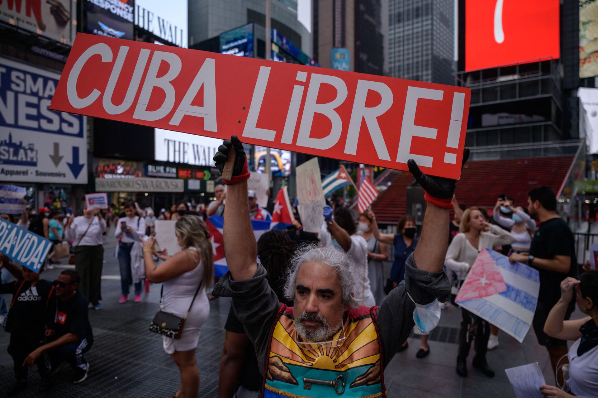 Demonstrators hold placards during a rally held in solidarity with anti-government protests in Cuba, in Times Square, New York on July 13, 2021. - One person died and more than 100 others, including independent journalists and dissidents, have been arrested after unprecedented anti-government protests in Cuba, with some remaining in custody on Tuesday, observers and activists said. - Sputnik International, 1920, 07.09.2021