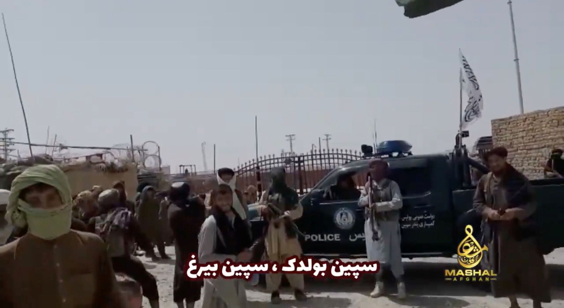 People stand in front of a vehicle as an Islamic Emirate of Afghanistan and a Pakistan's flag flutter in front of the friendship gate of Afghanistan and Pakistan at the Wesh-Chaman border crossing, Spin Boldak, Afghanistan July 14, 2021, in this screen grab obtained from a video - Sputnik International, 1920, 07.09.2021