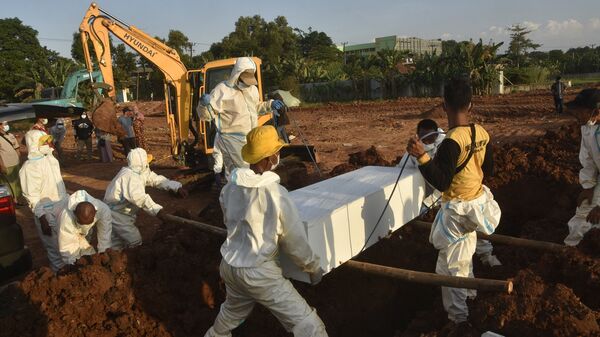 Gravediggers wearing personal protective equipment carry a coffin for burial at a cemetery in Bekasi on July 12, 2021, as Indonesia faces its most serious outbreak driven by the highly infectious Delta variant of Covid-19 - Sputnik International
