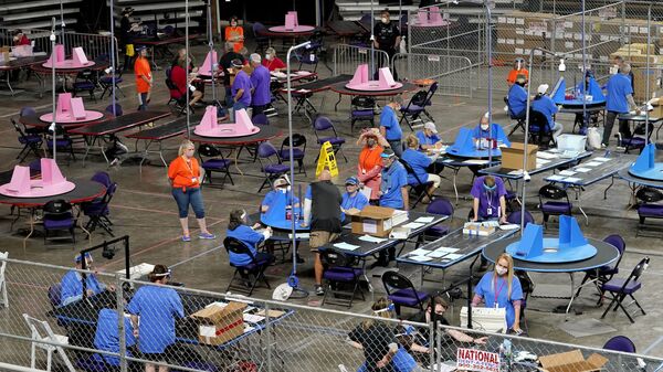 In this 6 May 2021 file photo, Maricopa County ballots cast in the 2020 general election are examined and recounted by contractors working for Florida-based company, Cyber Ninjas at the Veterans Memorial Coliseum in Phoenix. (AP Photo/Matt York, Pool, File) - Sputnik International