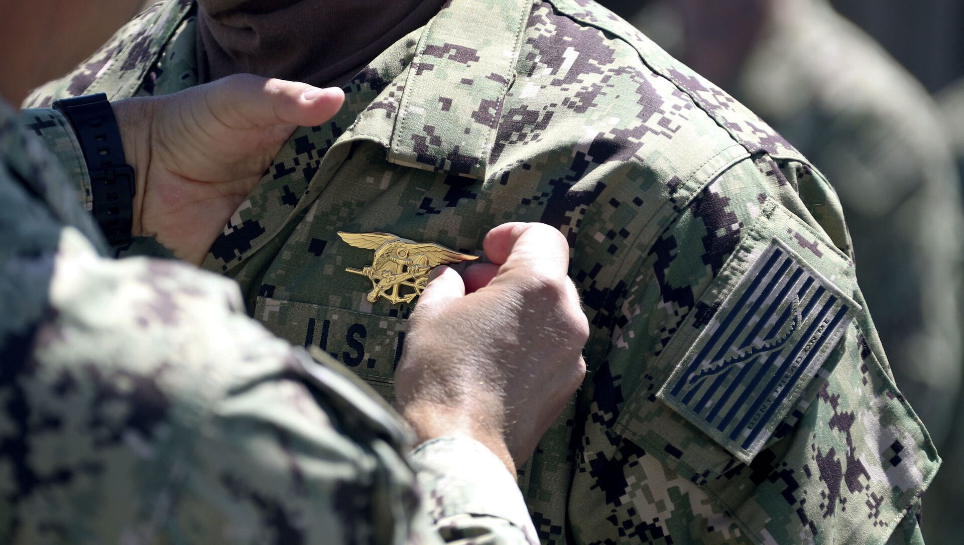 Commander places a special warfare pin on a member of SEAL Qualification Training Class 336 during a graduation ceremony - Sputnik International, 1920, 16.07.2021