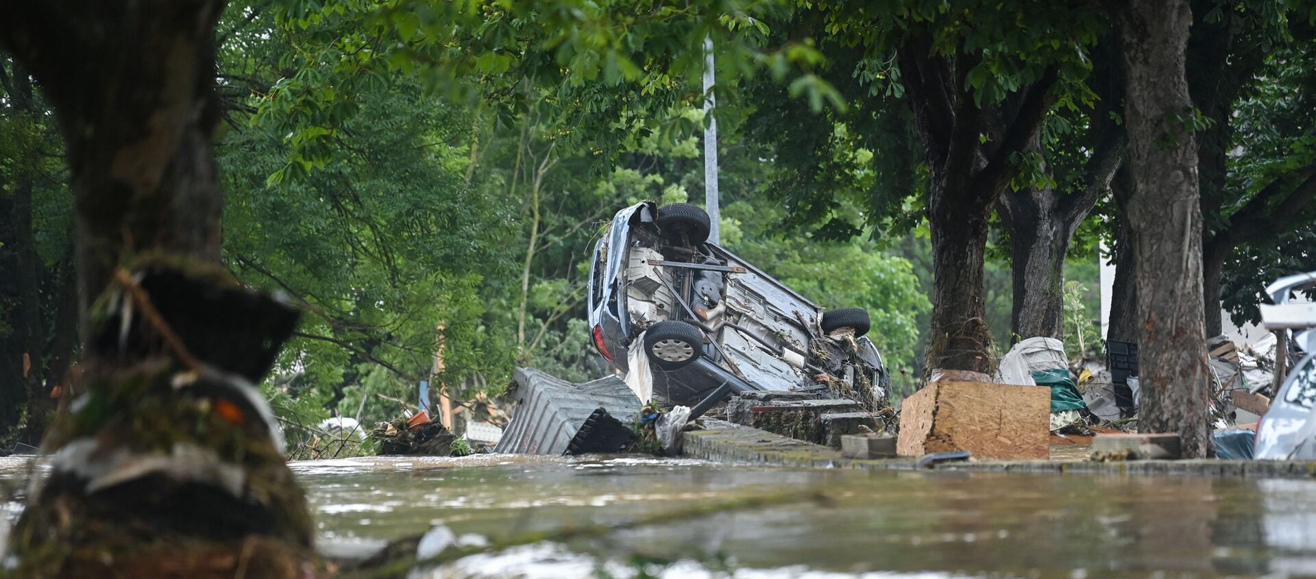 A car stands upside down near floating water in Iversheim, near Bad Muenstereifel, western Germany, on July 16, 2021, following heavy rains and floods. - The death toll from devastating floods in Europe soared to at least 126 on July 16, most in western Germany where emergency responders were frantically searching for missing people. - Sputnik International, 1920, 17.07.2021