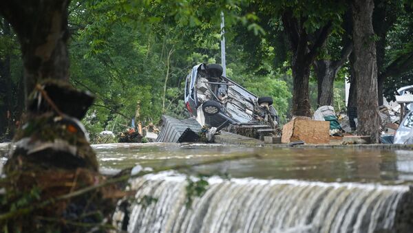 A car stands upside down near floating water in Iversheim, near Bad Muenstereifel, western Germany, on July 16, 2021, following heavy rains and floods. - The death toll from devastating floods in Europe soared to at least 126 on July 16, most in western Germany where emergency responders were frantically searching for missing people. - Sputnik International