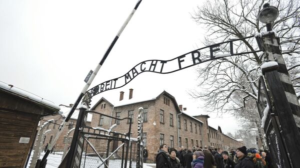 Visitors and media stand by the entrance gate of the Auschwitz Nazi death camp in Oswiecim, Poland, Monday, Jan. 26, 2015 - Sputnik International