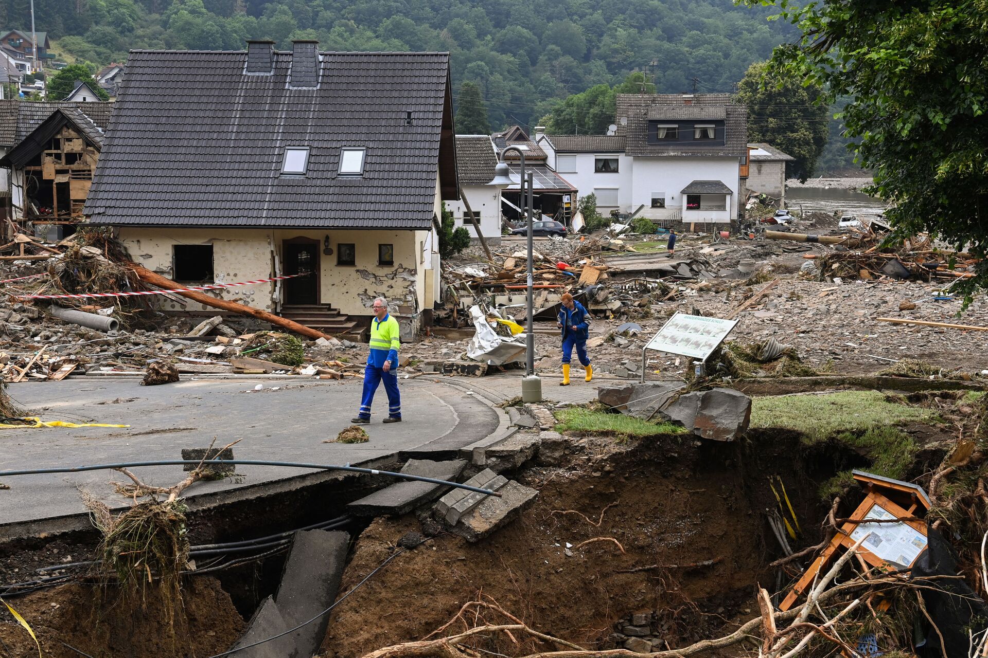 Two men walk on a partially slipped road amid destroyed houses after the floods caused major damage in Schuld near Bad Neuenahr-Ahrweiler, western Germany, on July 16, 2021. - Sputnik International, 1920, 07.09.2021