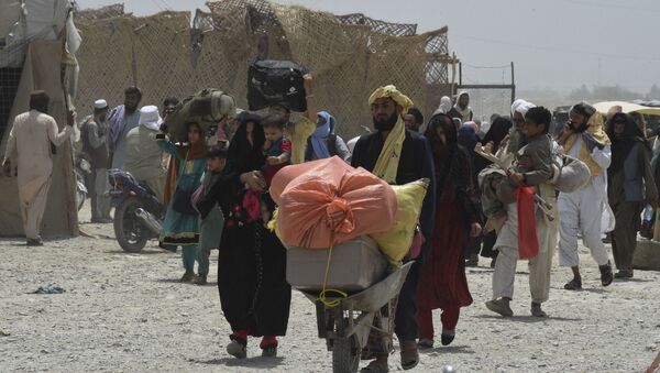 People walk towards a border crossing point in Pakistan's border town of Chaman on July 17, 2021, after Pakistan partially reopened its southern crossing with Afghanistan, shut off since the Taliban seized control of the strategic border town on the other side.  - Sputnik International