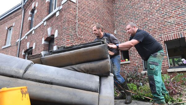 Residents removed damaged furniture from a home following heavy rains and floods in the town of Rochefort on July 17, 2021. - Sputnik International