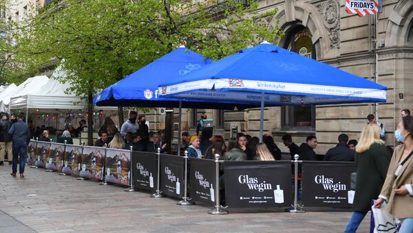 Customers sit at outside tables at a re-opened TGI Fridays restaurant in Glasgow on April 26, 2021 following the relaxing of some Covid-19 restrictions in Scotland, after the third national lockdown.  - Sputnik International