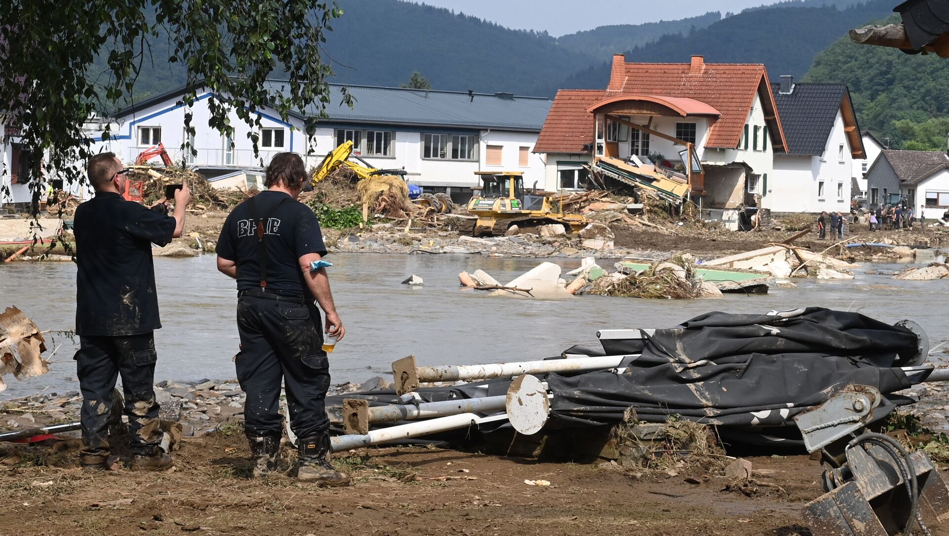 A worker (L) takes a picture of a destroyed area in Insul near Bad Neuenahr-Ahrweiler, western Germany, on July 17, 2021. - Devastating floods in Germany and other parts of western Europe have been described as a catastrophe, a war zone and unprecedented, with more than 150 people dead and the toll still climbing on July 17, 2021 - Sputnik International, 1920, 28.07.2021