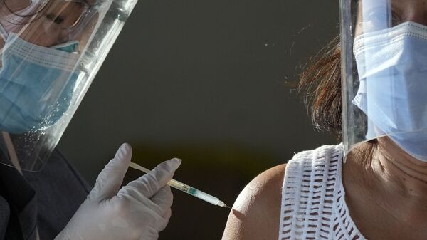 In this 22 June 2021 file photo, a health worker inoculates a woman with China's Sinovac COVID-19 vaccine at a temporary vaccination centre in Manila, Philippines - Sputnik International