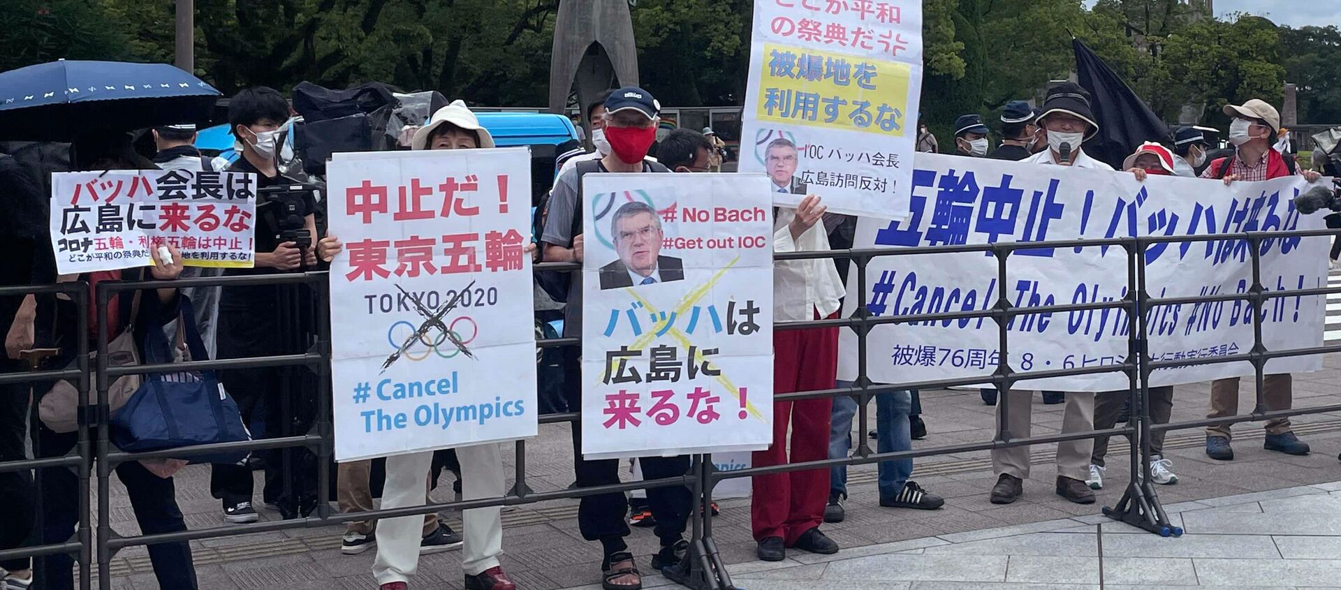 Protesters hold banners and placards including one (C) that reads Bach, Do not come to Hiroshima! ahead of the arrival of International Olympic Committee President Thomas Bach to the Hiroshima Memorial Cenotaph, in Hiroshima on July 16, 2021.  - Sputnik International, 1920, 18.07.2021