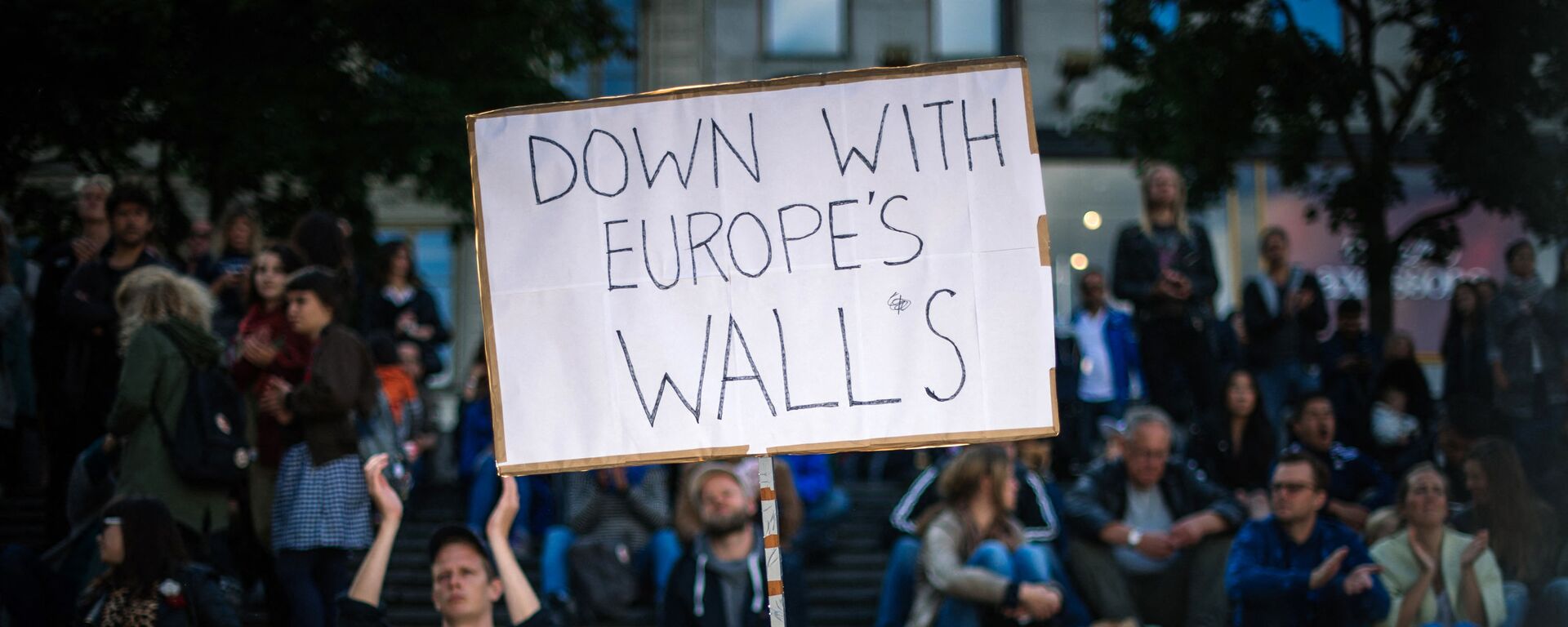 A man holds a sign as he takes part in a demonstration in solidarity with migrants seeking asylum in Europe after fleeing their home countries in Stockholm on September 12, 2015. - Sputnik International, 1920, 20.07.2021