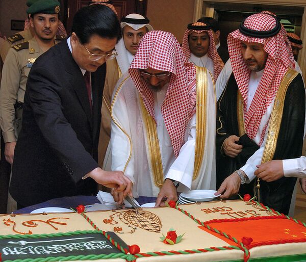 The chairman of the Saudi Shura consultative council, Sheikh Saleh bin Humaid (2nd L) and Chinese President Hu Jintao (L) cut a cake after Jintao's speech at the Shura Council in Riyadh on 23 April 2006. - Sputnik International
