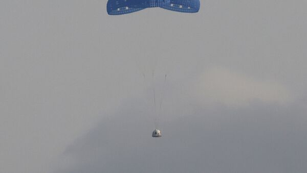 The capsule carrying billionaire businessman Jeff Bezos and three crew members returns by parachute after their flight aboard Blue Origin's New Shepard rocket near Van Horn, Texas , US, on 20 July 2021. - Sputnik International