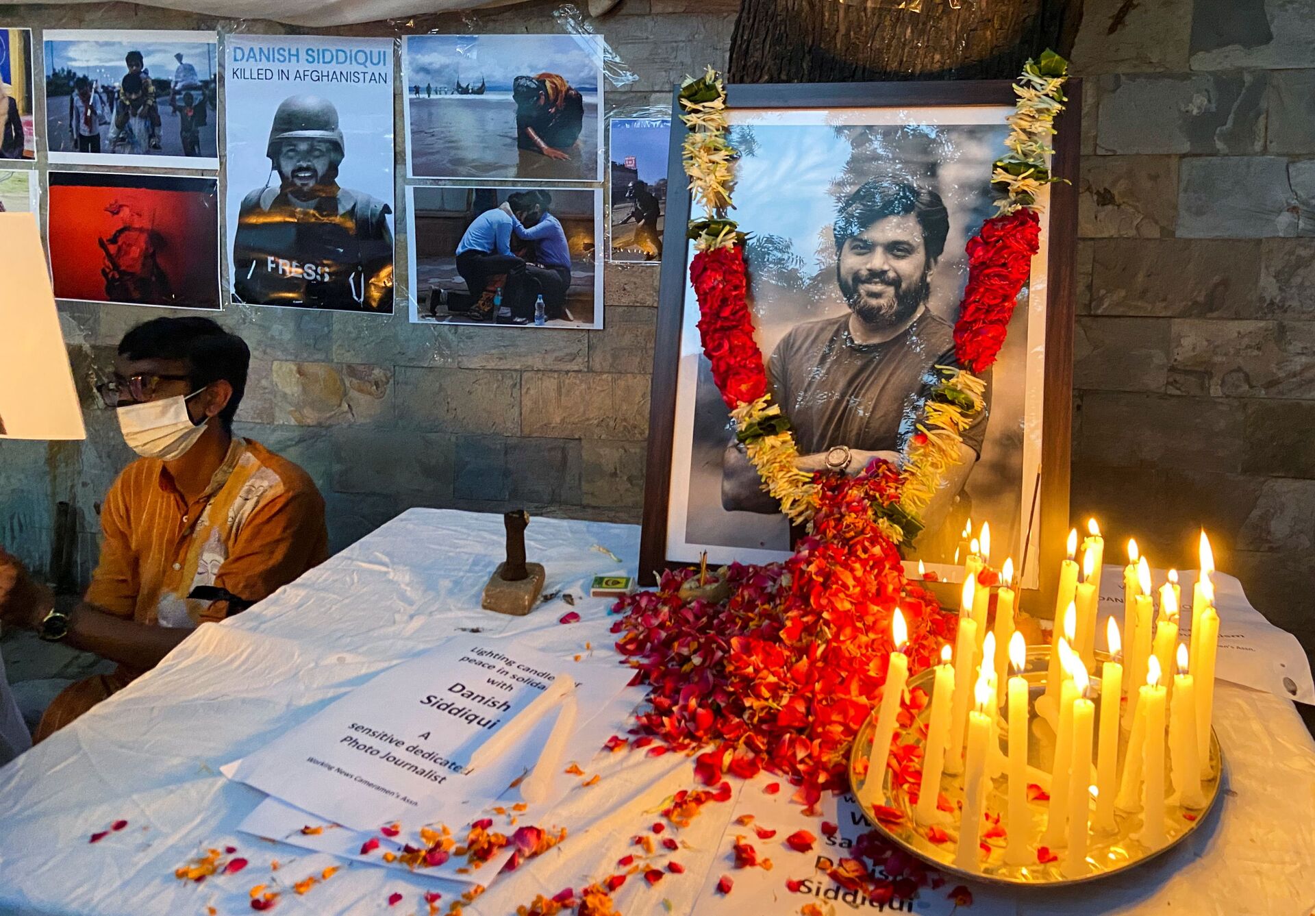 A man sits next to a memorial for Reuters journalist Danish Siddiqui, after he was killed while covering a clash between Afghan security forces and Taliban fighters near a border crossing with Pakistan, outside the Press Club in New Delhi, India, July 17, 2021.  - Sputnik International, 1920, 07.09.2021