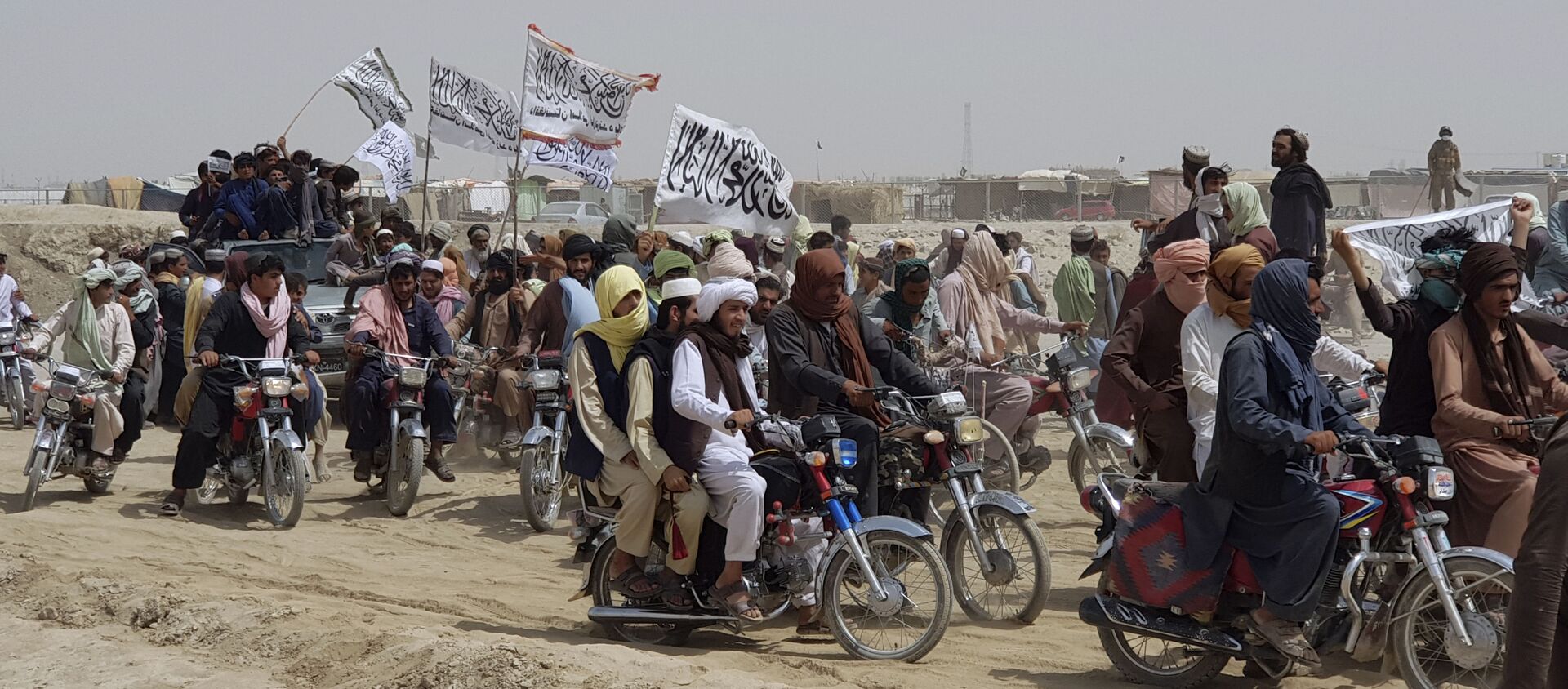Supporters of the Taliban carry the Taliban's signature white flags in the Afghan-Pakistan border town of Chaman, Pakistan, Wednesday, July 14, 2021 - Sputnik International, 1920, 01.08.2021