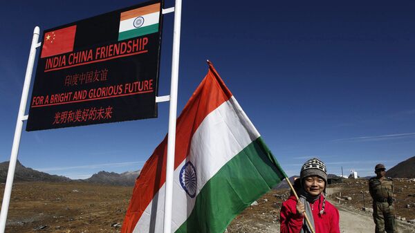 An Indian girl poses for photographs with an Indian flag at the Indo-China border at the Bum La Pass at an altitude of 15,700 feet (4,700 meters) above sea level in Arunachal Pradesh, India on Sunday 21 October 2012. - Sputnik International