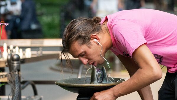 A man drinks from a water fountain in Washington Square park during a heat wave in New York City, New York, U.S., July 6, 2021.  - Sputnik International