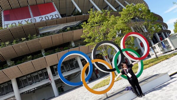 A woman poses in front of the National Stadium, the main stadium of Tokyo 2020 Olympics and Paralympics in Tokyo, Japan July 23, 2021. - Sputnik International