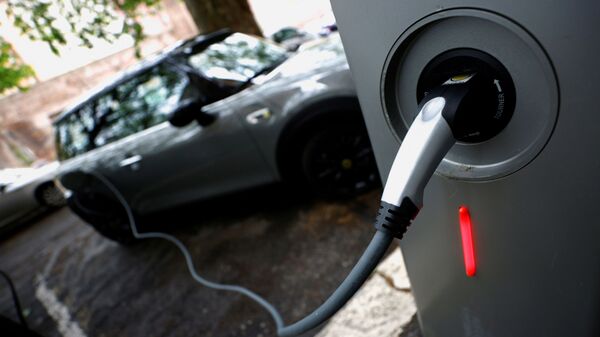 An electric car is seen plugged in at a charging point for electric vehicles (File) - Sputnik International