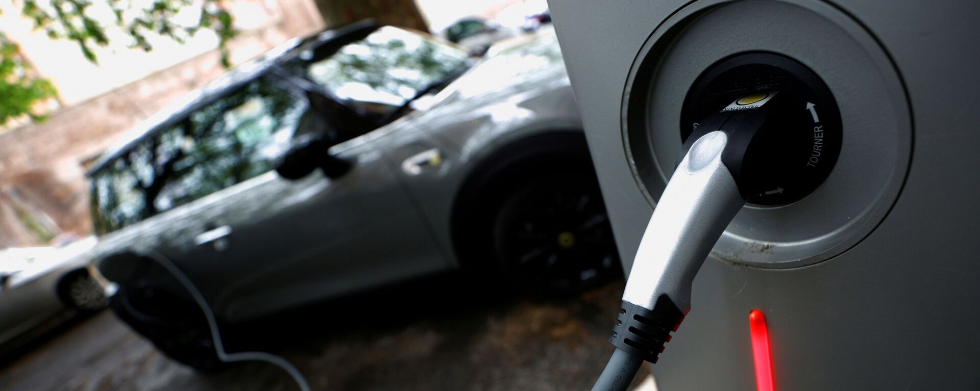 An electric car is seen plugged in at a charging point for electric vehicles (File) - Sputnik International, 1920, 06.09.2021