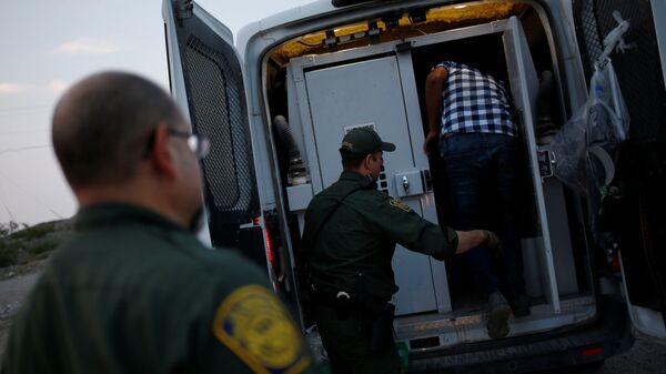 A migrant from Central America is detained by U.S. Border Patrol agents after crossing into the United States from Mexico, in Sunland Park, New Mexico, U.S., July 22, 2021 - Sputnik International