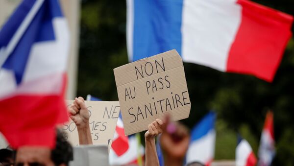 A protester holds a placard that reads No to the health passport during a demonstration called by the French nationalist party Les Patriotes (The Patriots) against France's restrictions to fight the coronavirus disease (COVID-19) outbreak, on the Droits de l'Homme (human rights) esplanade at the Trocadero Square in Paris, France, July 24, 2021.  - Sputnik International