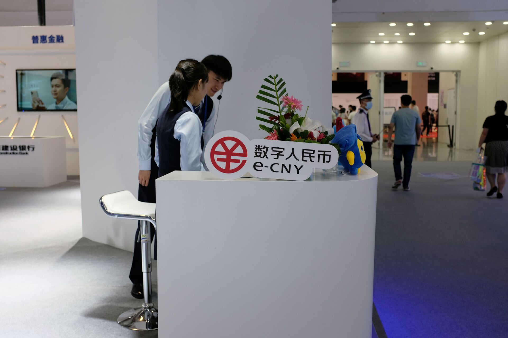 Staff members stand next to a sign of China's digital yuan, or e-CNY, at the World Artificial Intelligence Conference (WAIC) in Shanghai, China July 8, 2021. - Sputnik International, 1920, 07.09.2021