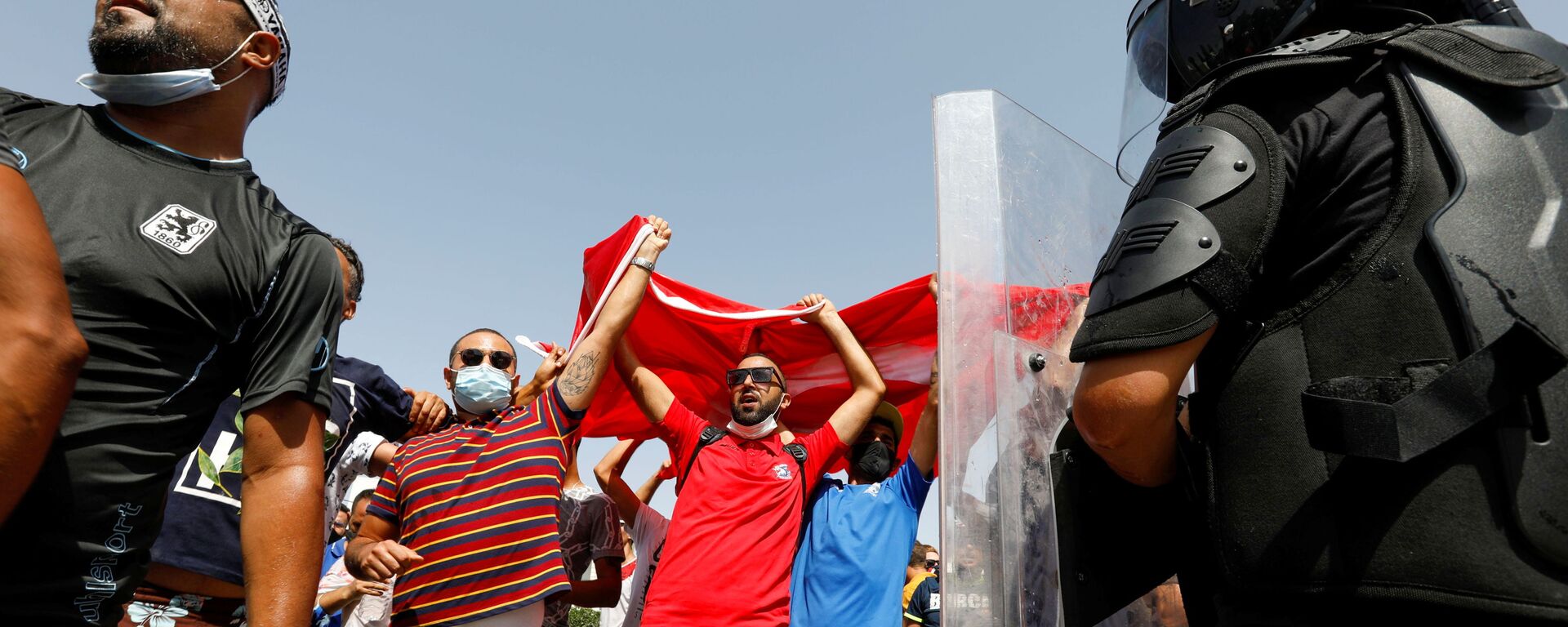 Supporters of Tunisia's President Kais Saied gather as a police officer stands guard near the parliament building in Tunis, Tunisia, July 26, 2021. - Sputnik International, 1920, 26.07.2021