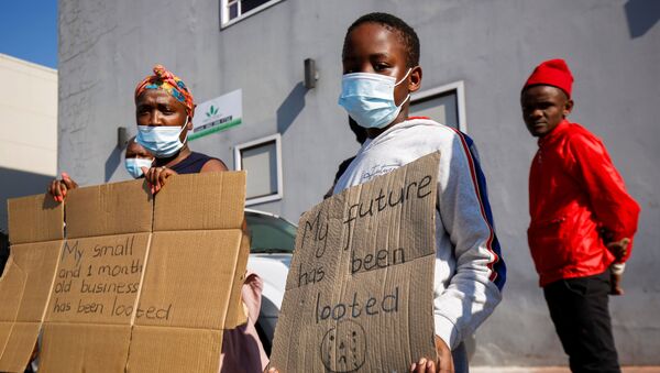 People stand with placards as South African President Cyril Ramaphosa visits a shopping centre which was damaged after several days of looting following the imprisonment of former South Africa President Jacob Zuma in Durban, South Africa, July 16, 2021. - Sputnik International