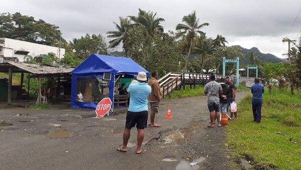 Family members wait at the entrance to a village settlement to deliver food to relatives that are in lockdown as an outbreak of the coronavirus disease (COVID-19) affects Lami, Fiji, June 26, 2021.  - Sputnik International