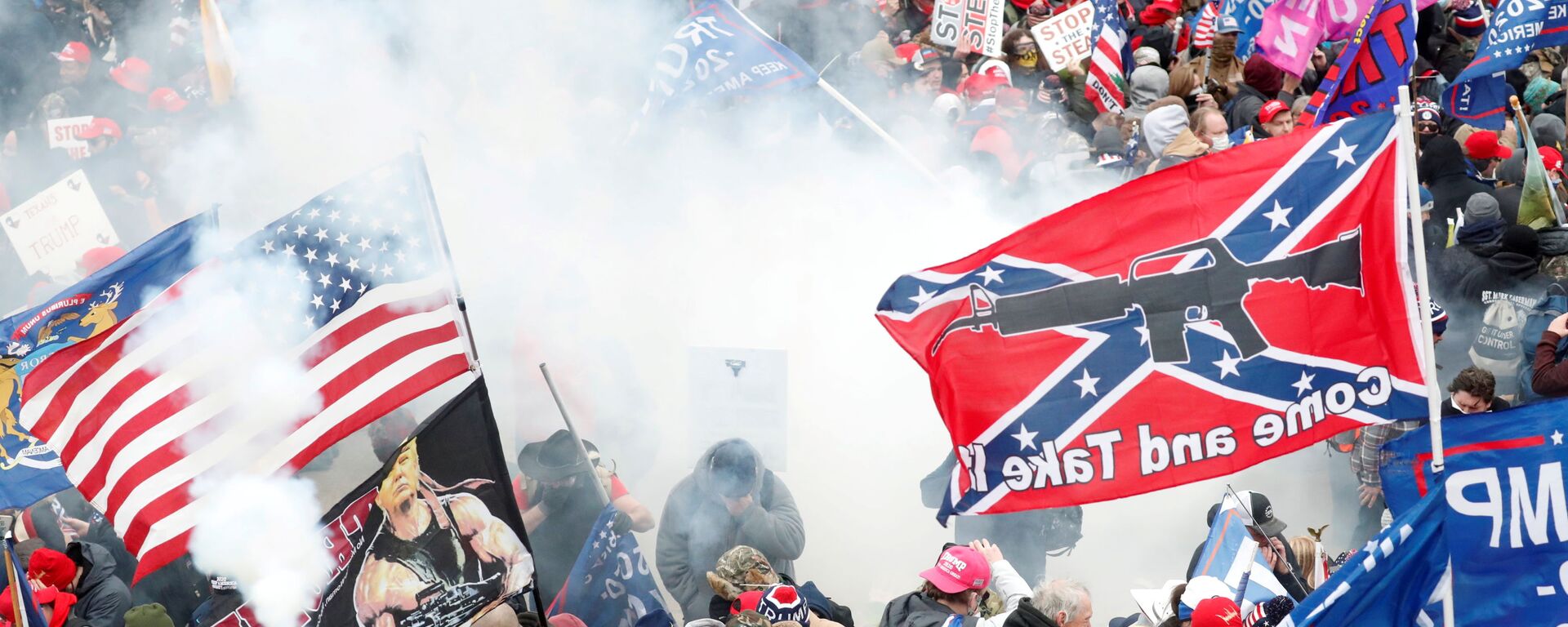 Tear gas is released into a crowd of protesters, with one wielding a Confederate battle flag that reads Come and Take It, during clashes with Capitol police - Sputnik International, 1920, 27.07.2021