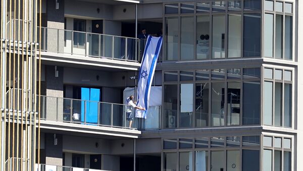 People hang an Israeli flag at the Athletes Village, where a person has tested positive for COVID-19, ahead of Tokyo 2020 Olympic Games in Tokyo, Japan July 17,  2021 - Sputnik International